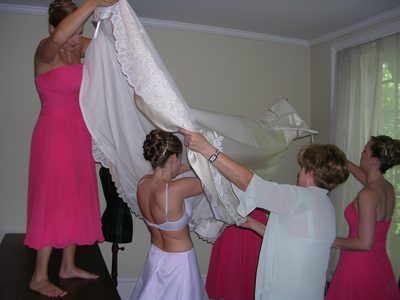 Putting the dress on the girl.